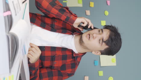 Vertical-video-of-Male-student-speaking-angrily-on-the-phone.